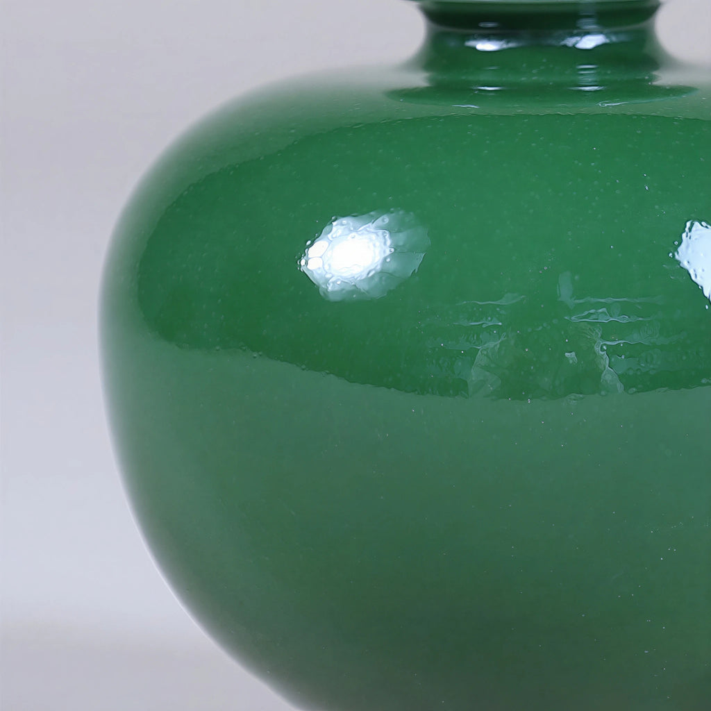 Close view of the emerald-green glaze surface on a rounded porcelain vase.
