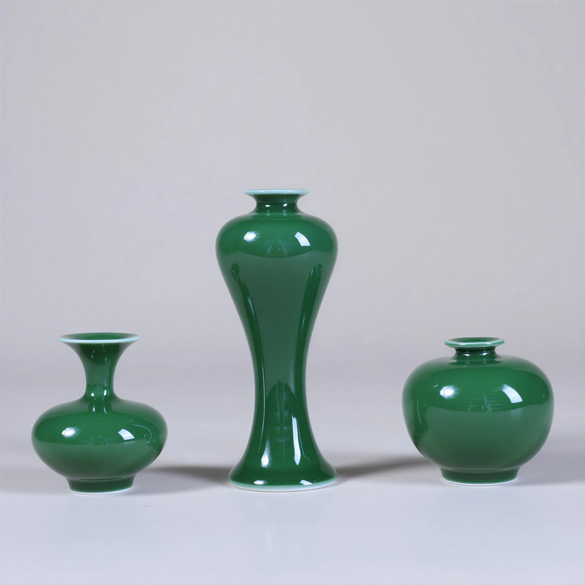 Three emerald-green miniature porcelain vases showing Meiping, squat, and rounded forms.