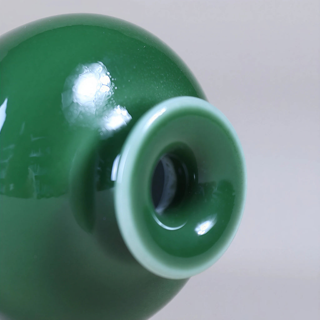 Close view of the narrow mouth opening and glossy emerald-green glaze.