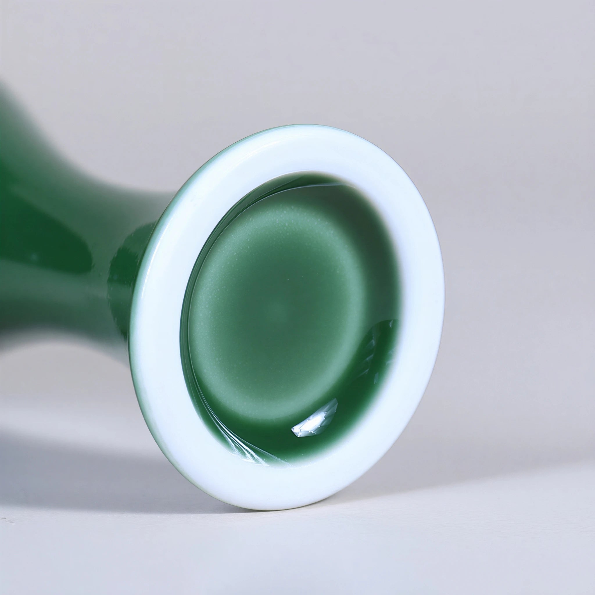Close view of the white porcelain foot ring and green glazed base.