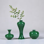 Three emerald-green Jingdezhen porcelain vases with a spring cutting in the center vase.