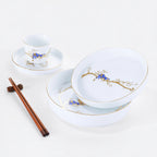 White porcelain Forest Rest place setting with three plates, a rice bowl, a cup, and wooden chopsticks.