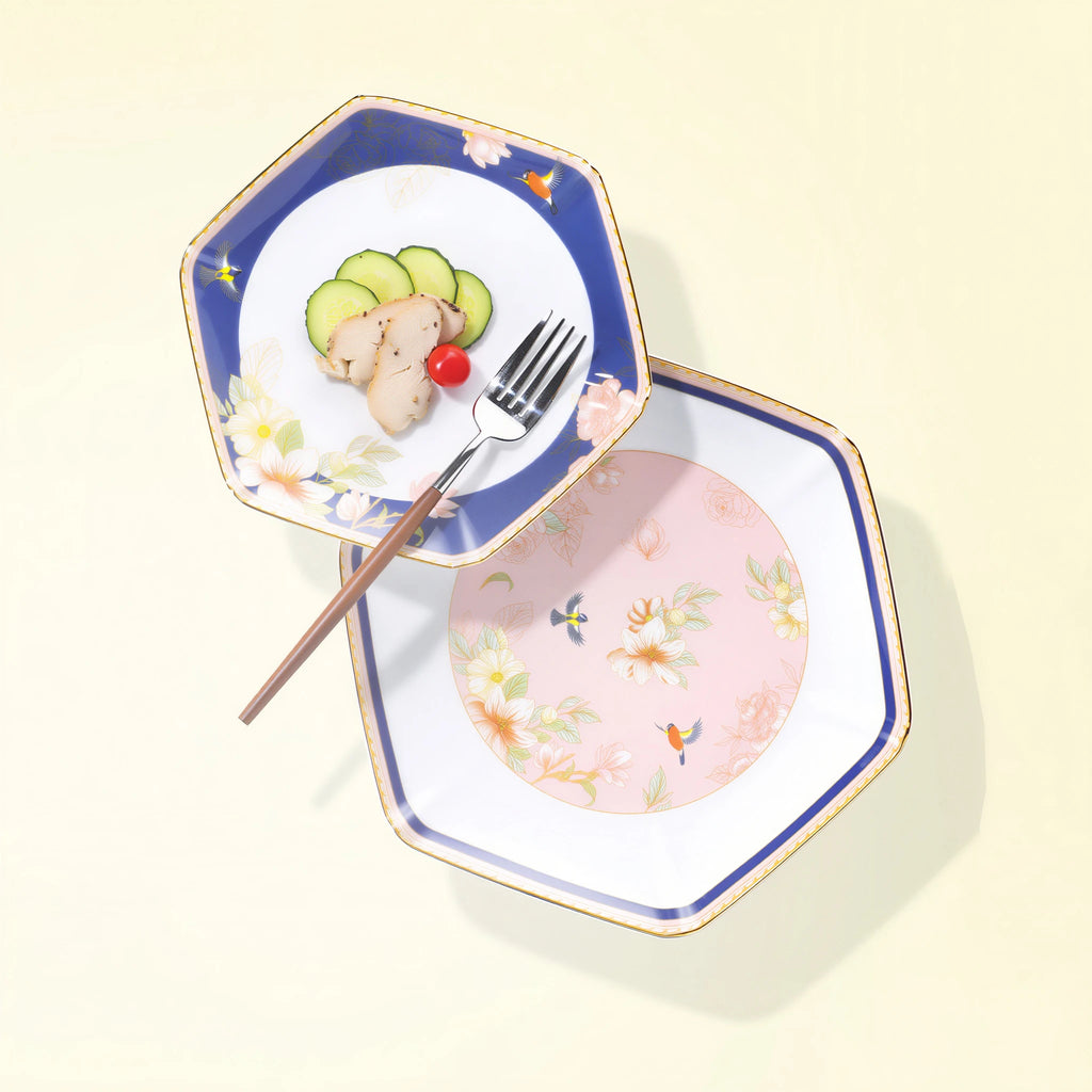 Two faceted Courtyard in Bloom porcelain plates styled with food, showing navy and blush floral fields.