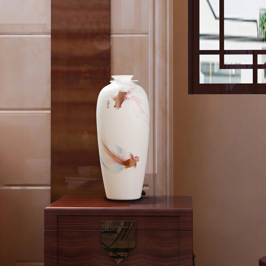 White porcelain goldfish Meiping vase displayed on a wooden cabinet in a warm interior