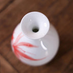 Close-up of the rounded mouth on a small white goldfish porcelain vase