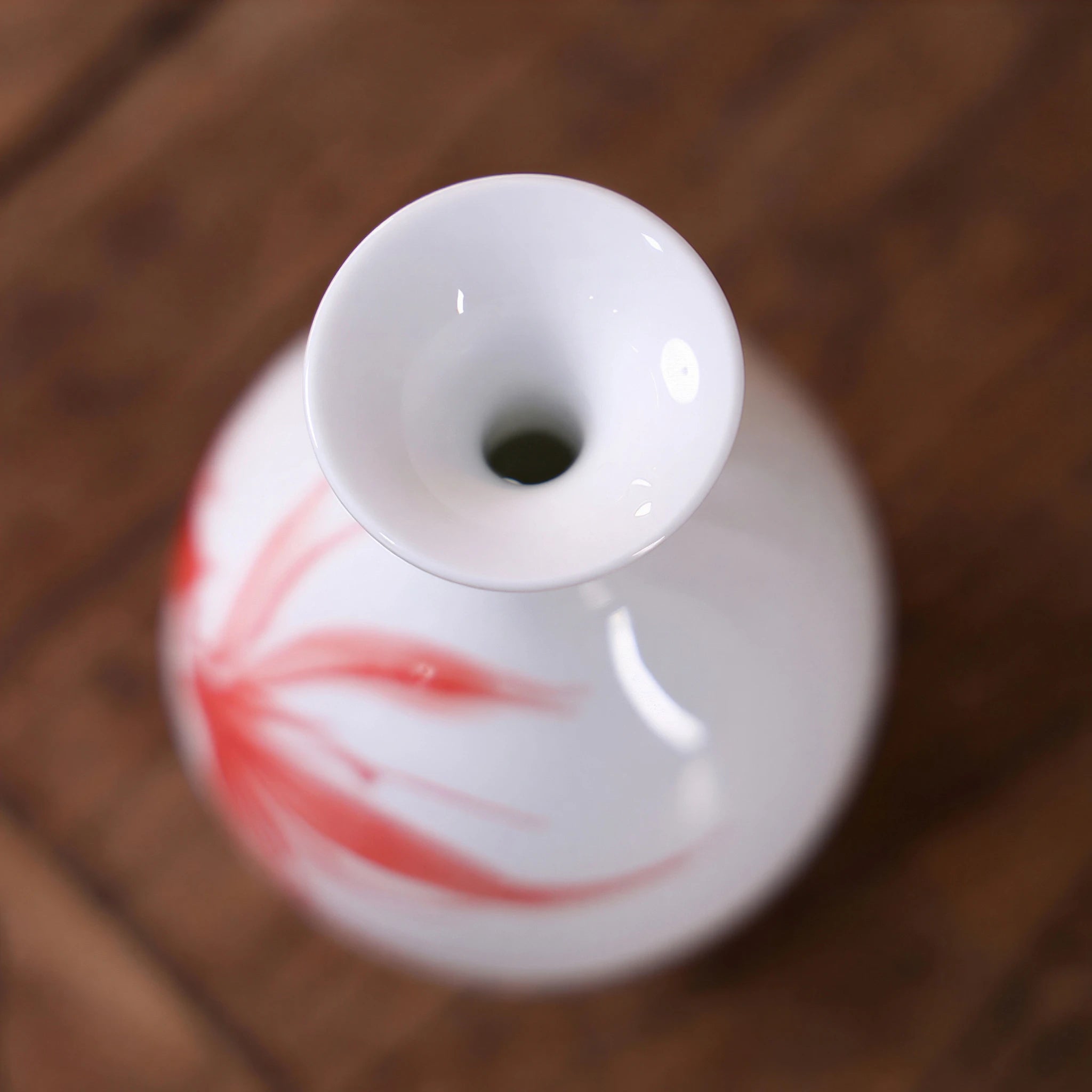 Close-up of the rounded mouth on a small white goldfish porcelain vase