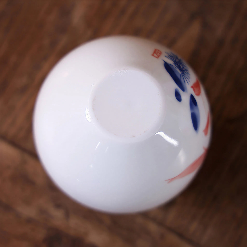 Smooth white base detail of a small hand-painted goldfish porcelain vase

