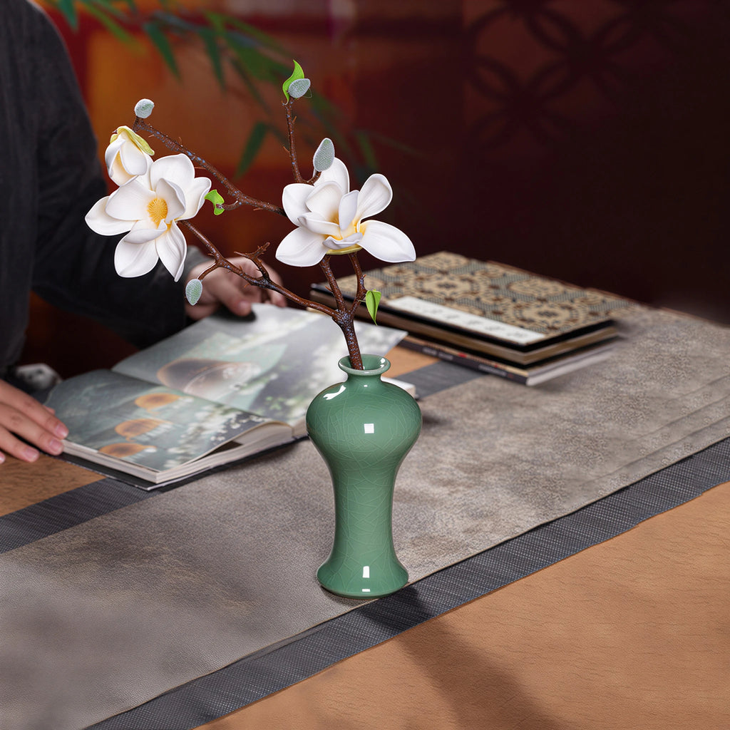 Hand arranging a magnolia stem in the Longquan bud vase