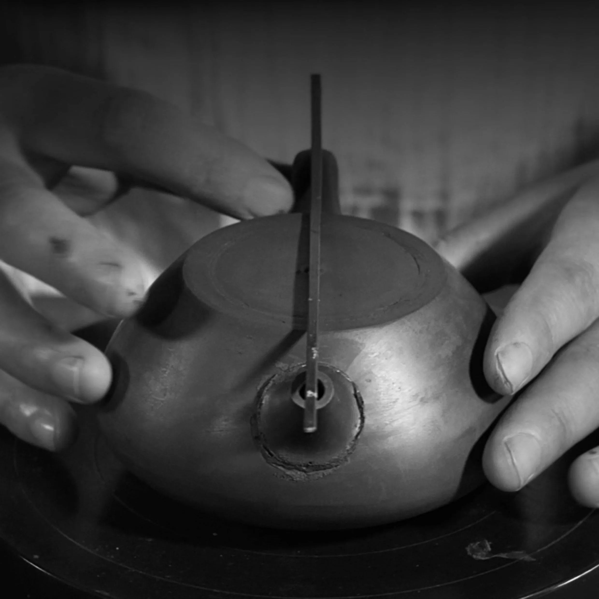 Artisan incising fine lines into an unfired zisha teapot body