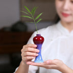 A rose-purple meiping mini vase held in two hands for scale.