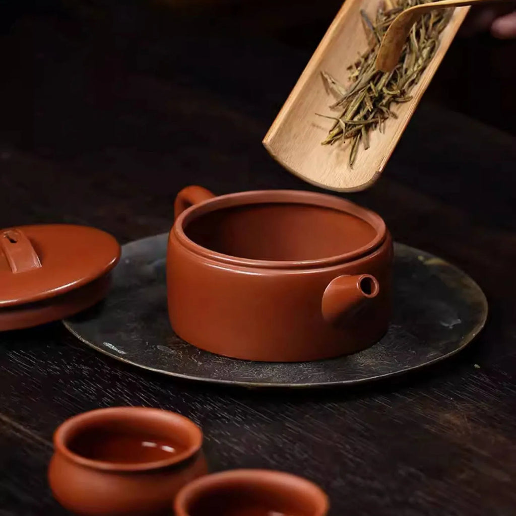 Whole tea leaves being placed through the Hanwa teapot's wide mouth