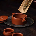 Whole tea leaves being placed through the Hanwa teapot's wide mouth