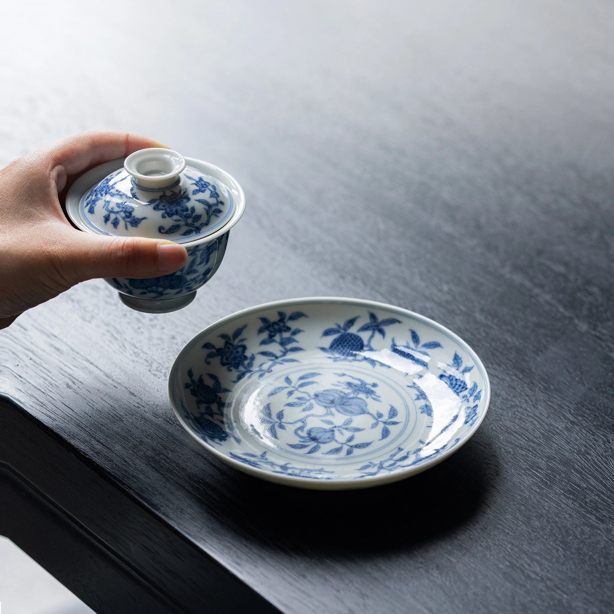 Hand holding the flared rim of the San Duo gaiwan