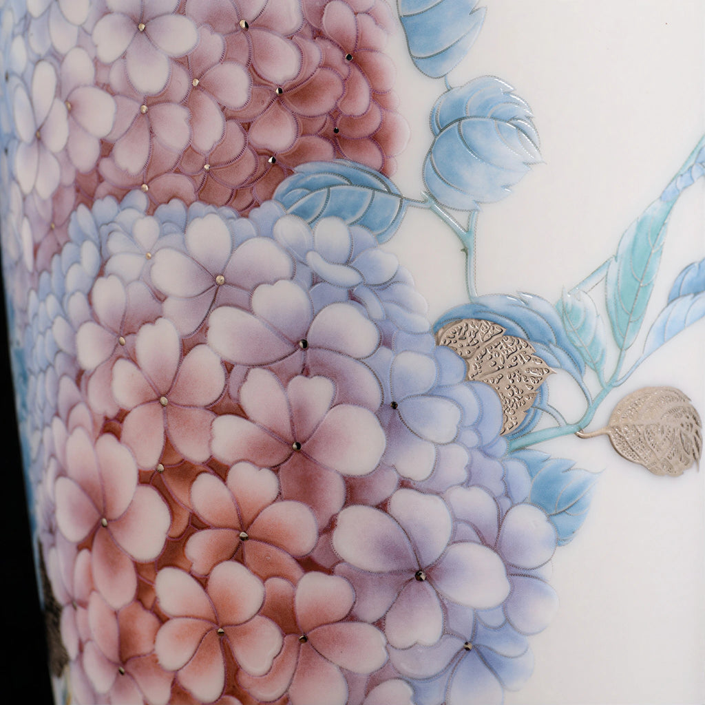 Close view of layered pink and blue hydrangea clusters on the white porcelain body