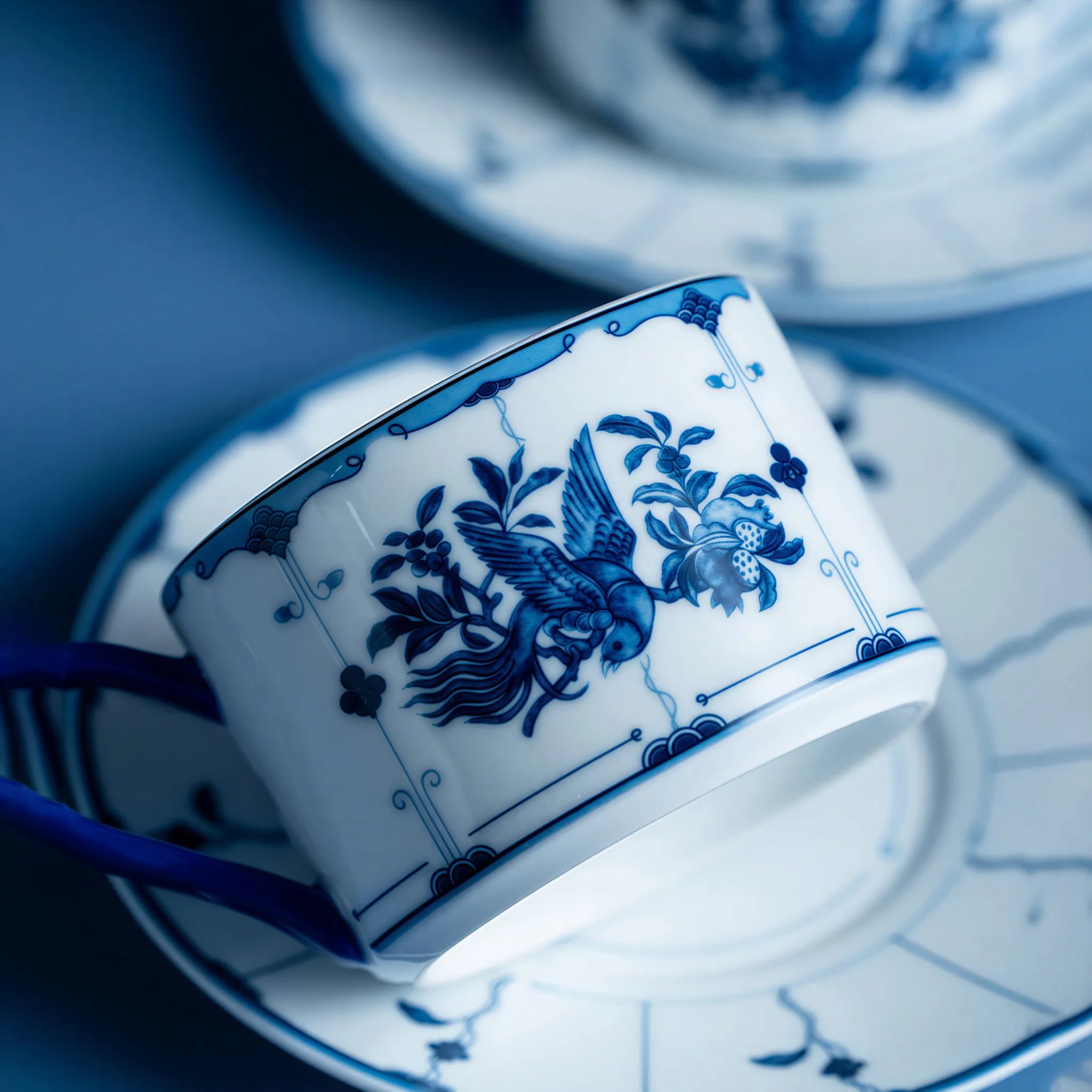 Cobalt-blue ribbon bird and tail detail on white porcelain