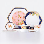 Complete eight-piece Jingdezhen Courtyard in Bloom porcelain place setting with navy and blush flower-and-bird decoration.