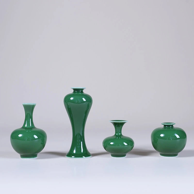 Four emerald-green Jingdezhen miniature porcelain vases on a pale studio background.