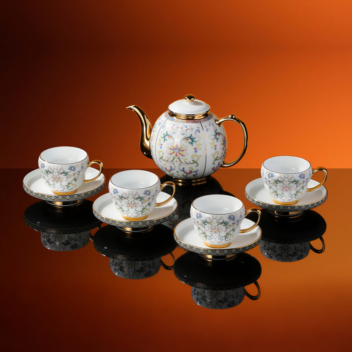 Floral porcelain service with four cups, four footed saucers and one lidded serving pot against an orange background.