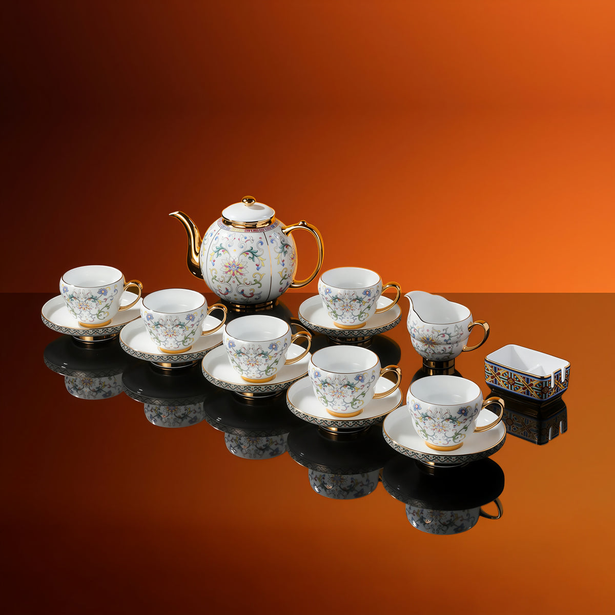 Floral porcelain service with six cups, six saucers, a lidded pot, a milk pitcher and a rectangular sugar vessel.