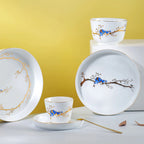 Forest Rest porcelain plates, rice bowl, and cup arranged against a yellow backdrop.