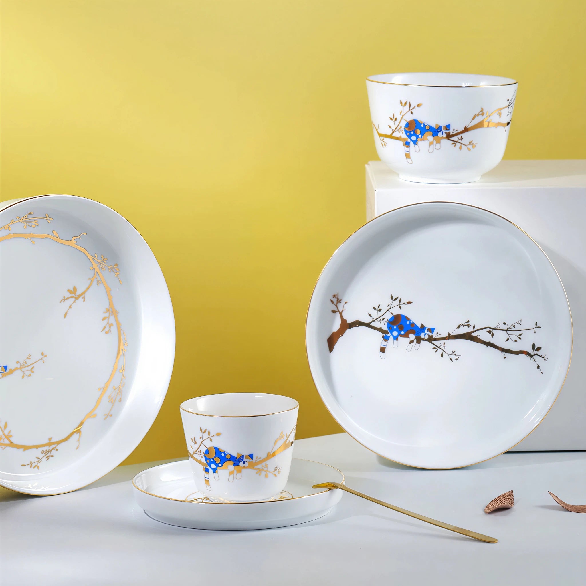Forest Rest porcelain plates, rice bowl, and cup arranged against a yellow backdrop.