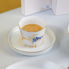 Forest Rest porcelain cup filled with tea and placed on the smallest gold-rimmed plate.