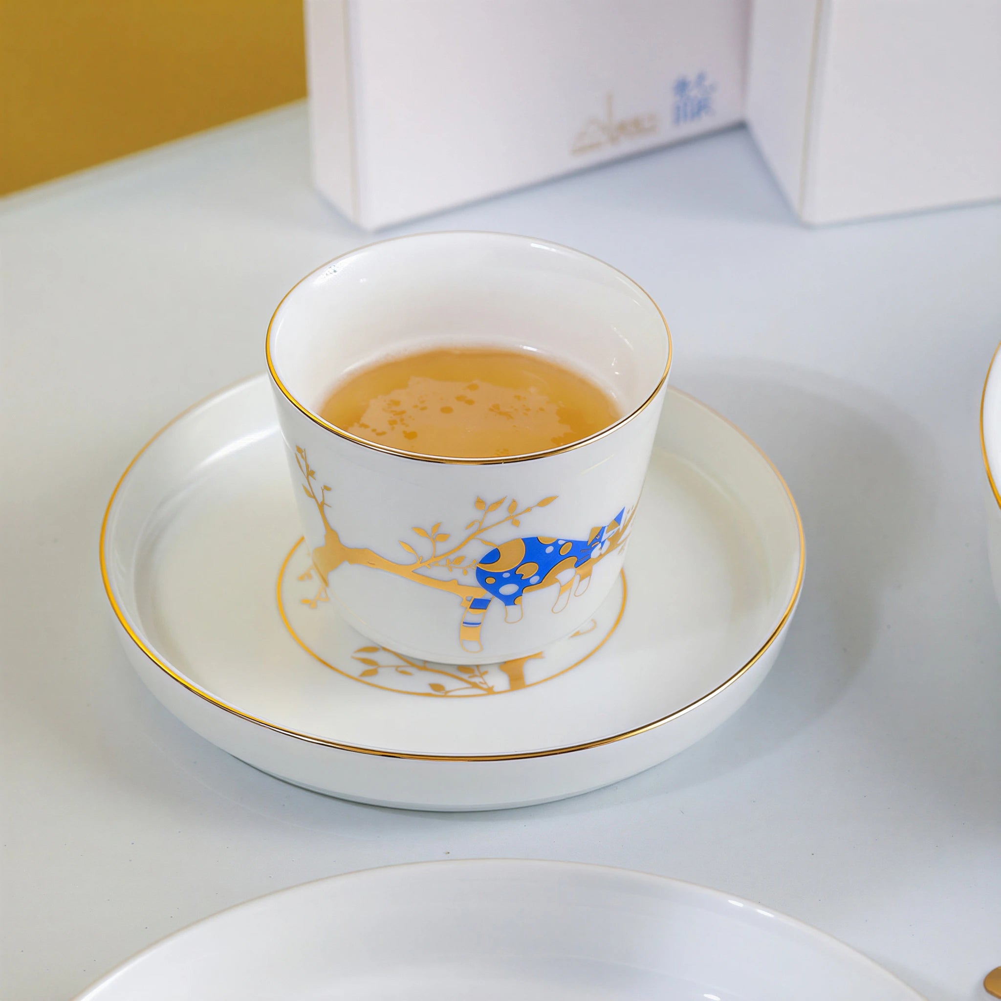 Forest Rest porcelain cup filled with tea and placed on the smallest gold-rimmed plate.