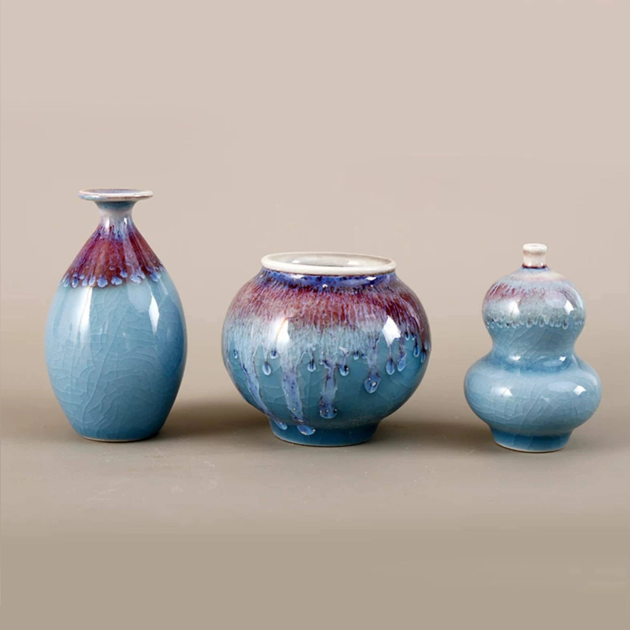 Trio of hand-thrown Jingdezhen porcelain vases showing blue and violet glaze variation