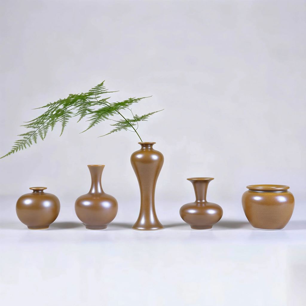 Five hand-thrown Jingdezhen maple-yellow mini porcelain vases arranged with a fern stem.
