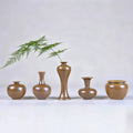 Five hand-thrown Jingdezhen maple-yellow mini porcelain vases arranged with a fern stem.