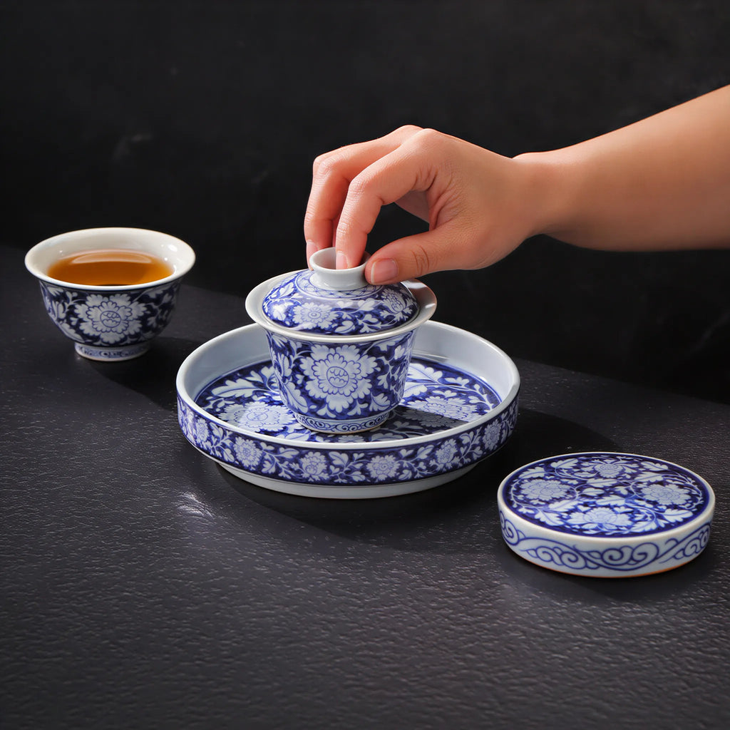 Hands arranging the in-glaze peony gongfu tea set