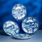 Three Silk Road porcelain plates displayed upright and flat against a blue backdrop.