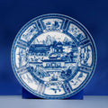 Jingdezhen Silk Road porcelain plate shown upright on a blue display stand.