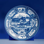 Jingdezhen Silk Road porcelain plate shown upright on a blue display stand.