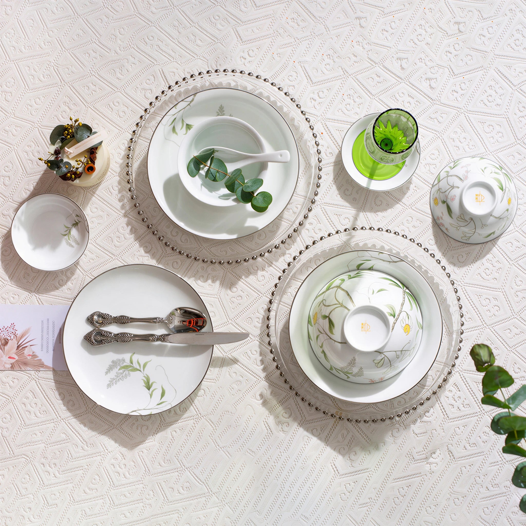Overhead view of Spring Dawn porcelain bowls, plates, dishes, and spoons with one bowl turned to show its orange underside mark.
