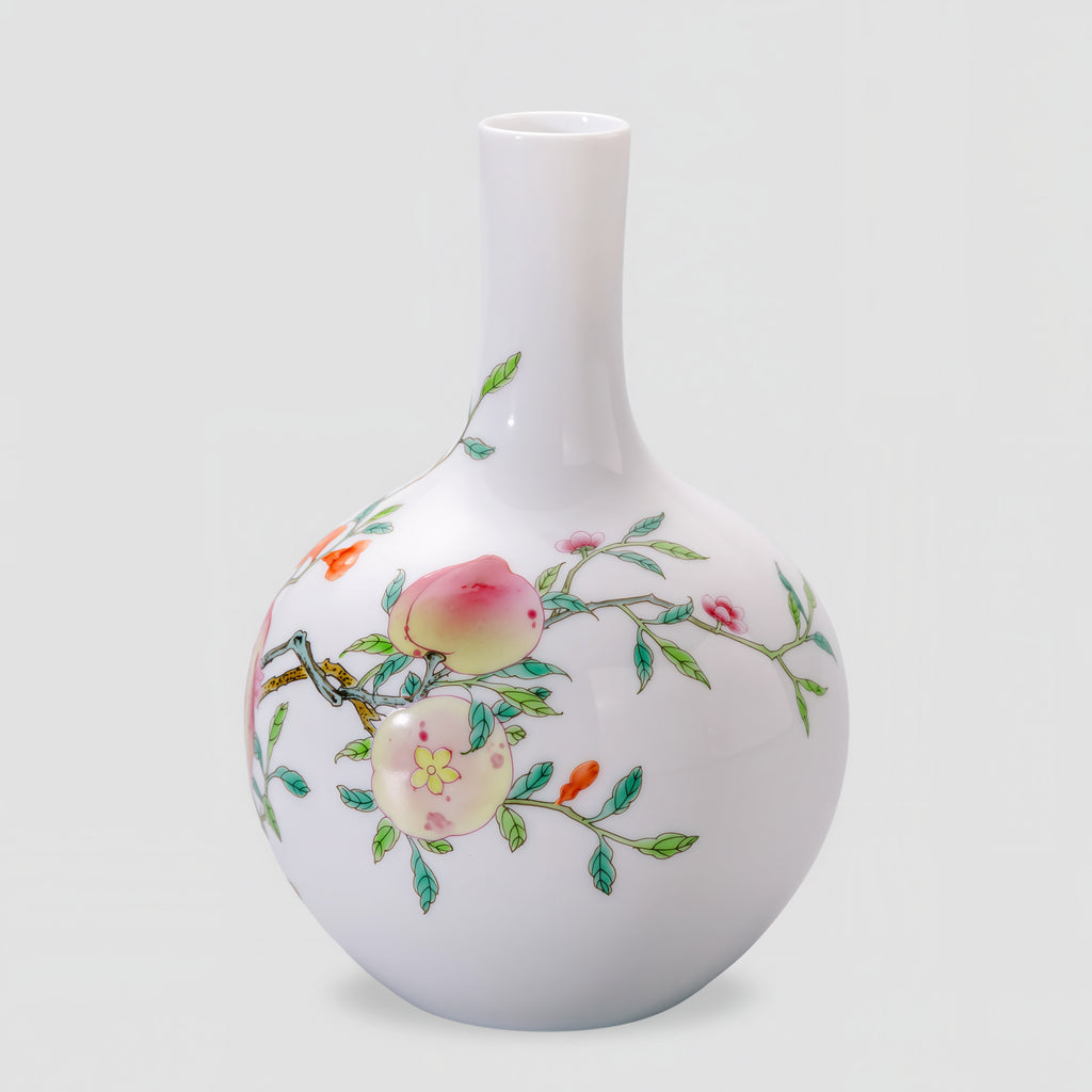 Side view of the Tianqiu vase with pale pink fruit, green leaves and fine branches on white porcelain.