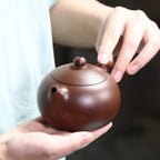 Fitted lid being lifted from the zini Xishi teapot