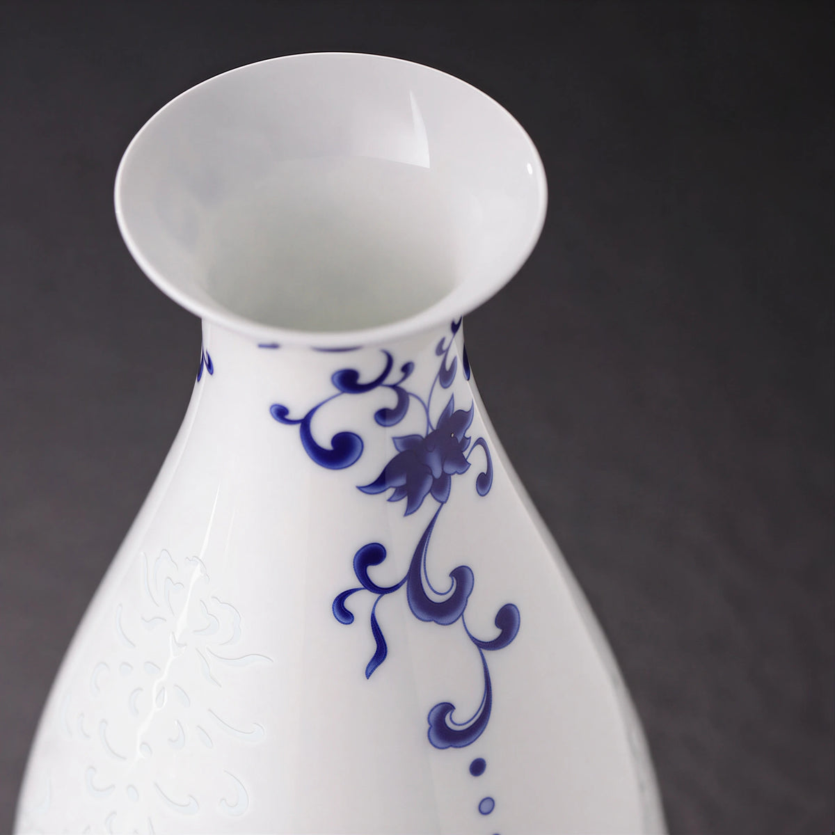 Close view of the flared mouth, cobalt neck scroll and white porcelain shoulder
