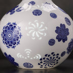 Close view of a translucent floral linglong window between cobalt medallions