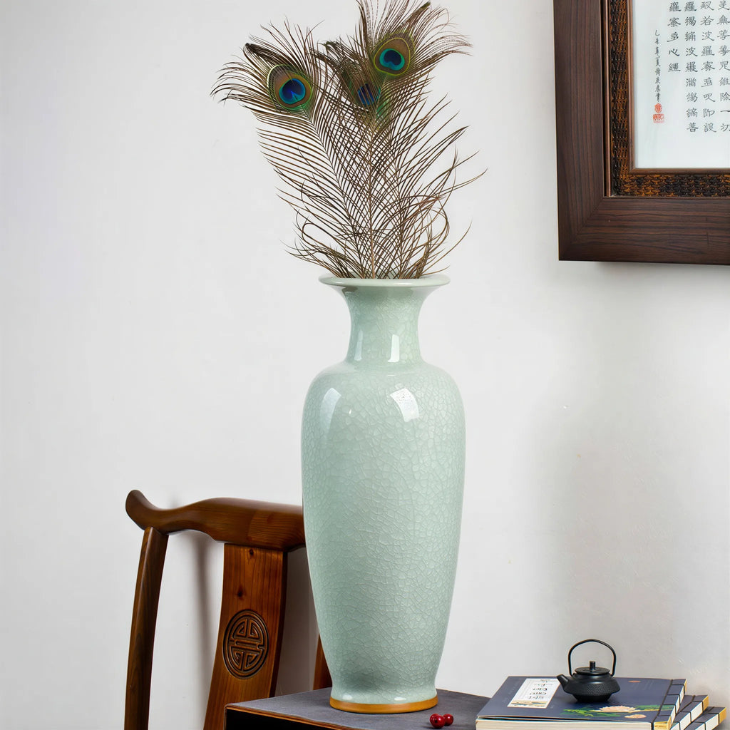 Pale celadon floor vase arranged with peacock feathers