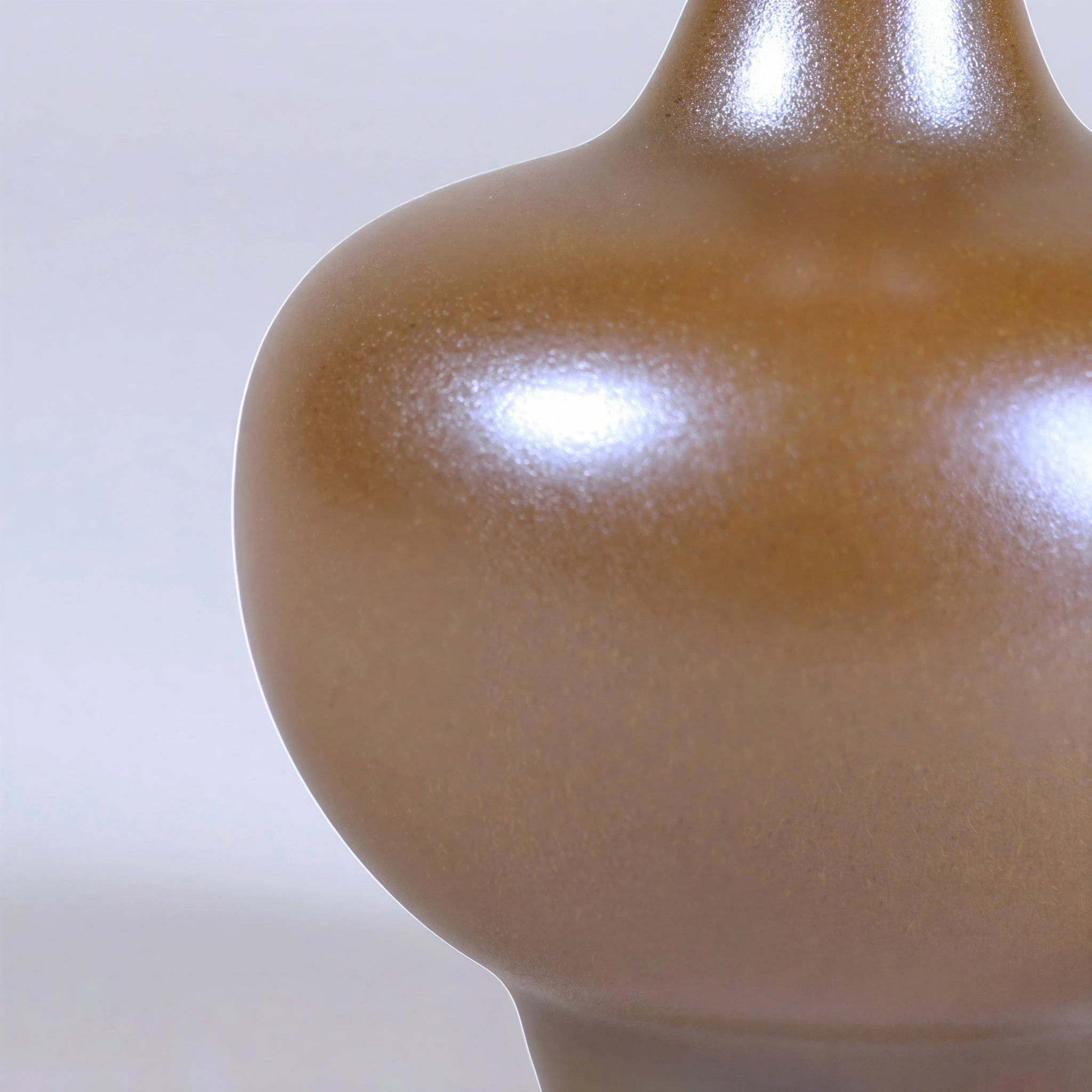 Close view of the curved maple-yellow glazed porcelain surface.