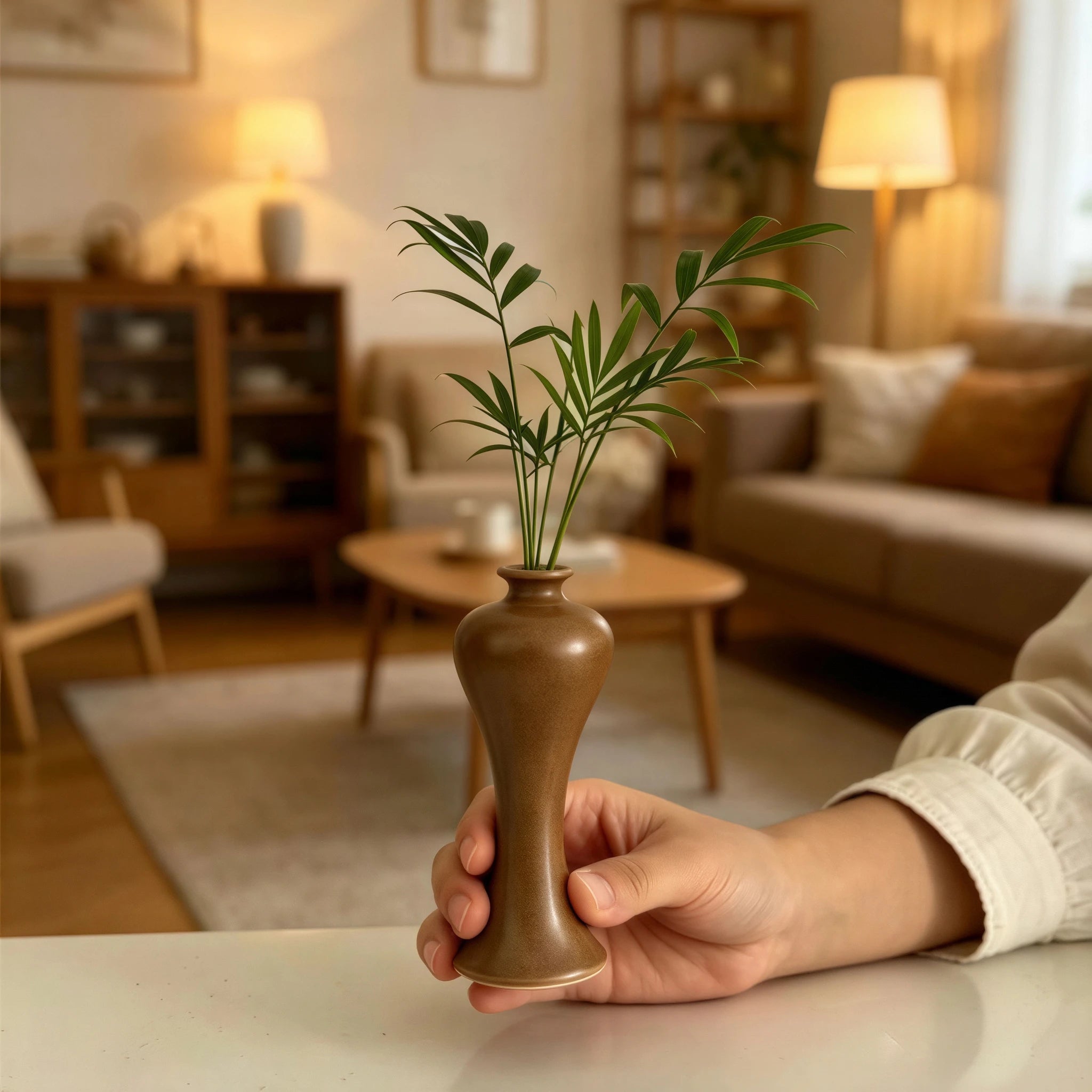 Handheld maple-yellow Meiping mini porcelain vase styled in a warm living room.