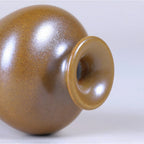 Close view of the narrow mouth and glossy maple-yellow glaze.