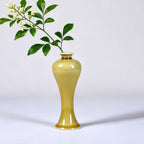 Slender luminous yellow porcelain meiping vase holding a green branch
