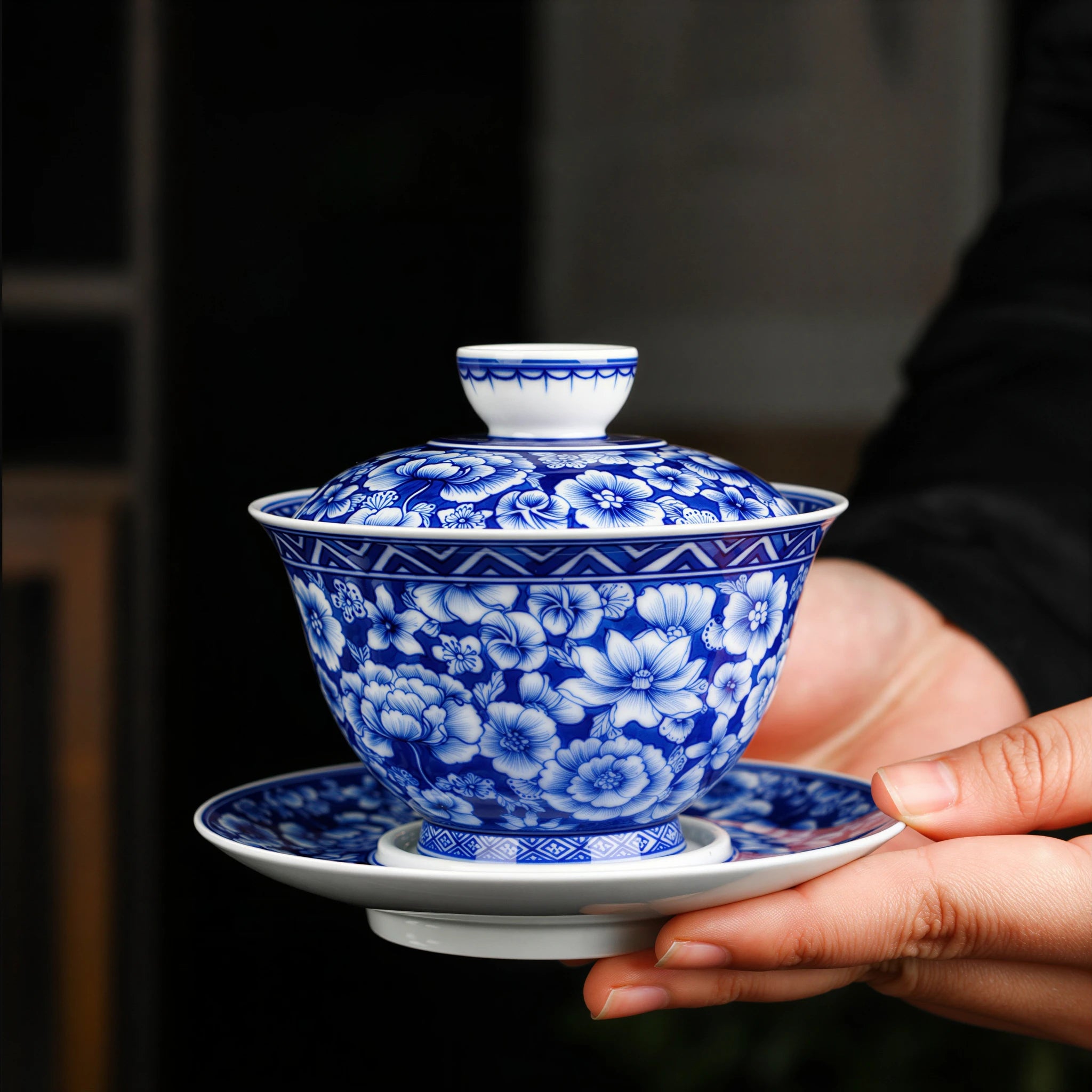 Complete millefleurs gaiwan held in two hands