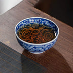Millefleurs teacup filled with tea on a bamboo mat