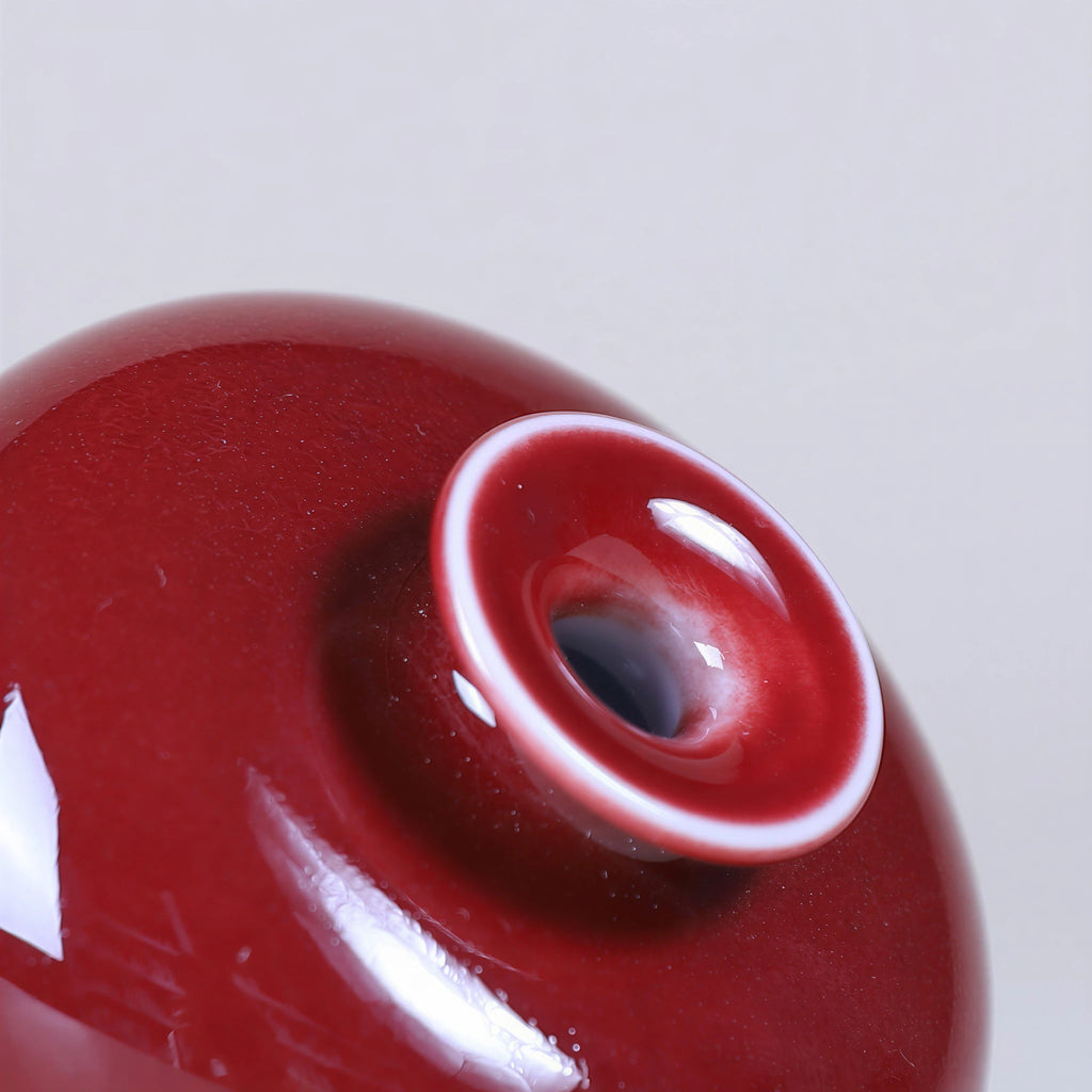 Close view of glossy oxblood red glaze around the mouth and shoulder