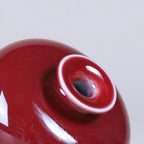 Close view of glossy oxblood red glaze around the mouth and shoulder