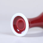 White foot ring detail on an oxblood red porcelain vase