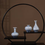 Three pale-blue crackle-glaze porcelain vases on a circular display stand.